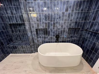 Modern curbless shower and freestanding bathtub, wall niches